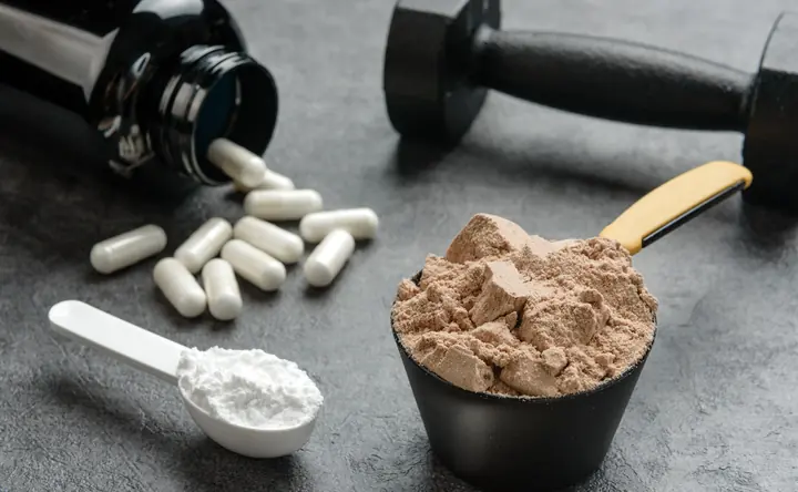 Suplementos, whey protein e halteres